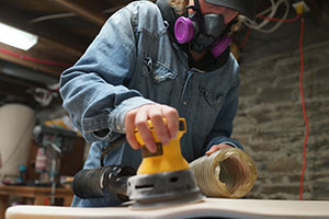 Andre Aitkens sanding a longboard