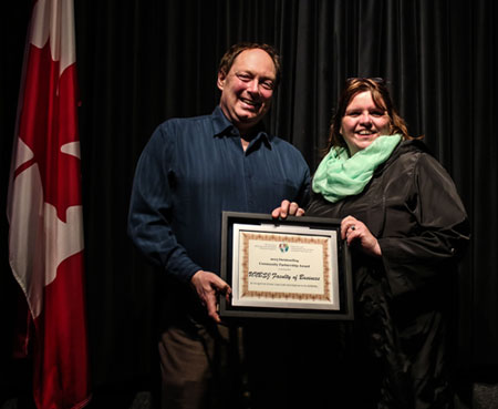 Drs. Rob Moir, Associate Dean (Research and Special Projects) and Shelley Rinehart, MBA Director, receive the Outstanding Community Partnership Award plaque.