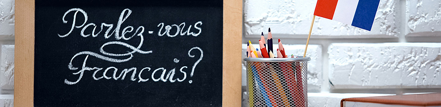 Photograph of a chalkboard sign with "Parlez-vous français" written in white chalk.