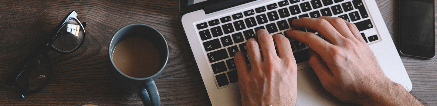 Hands typing on laptop keyboard