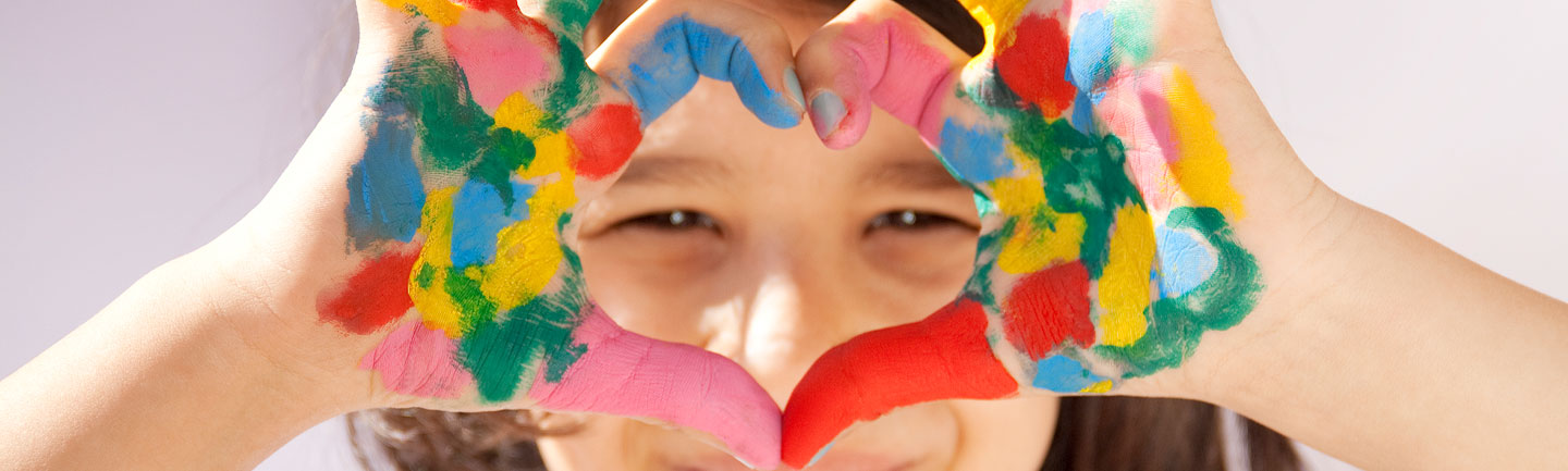 Photo of a young girl making a heart with her hands