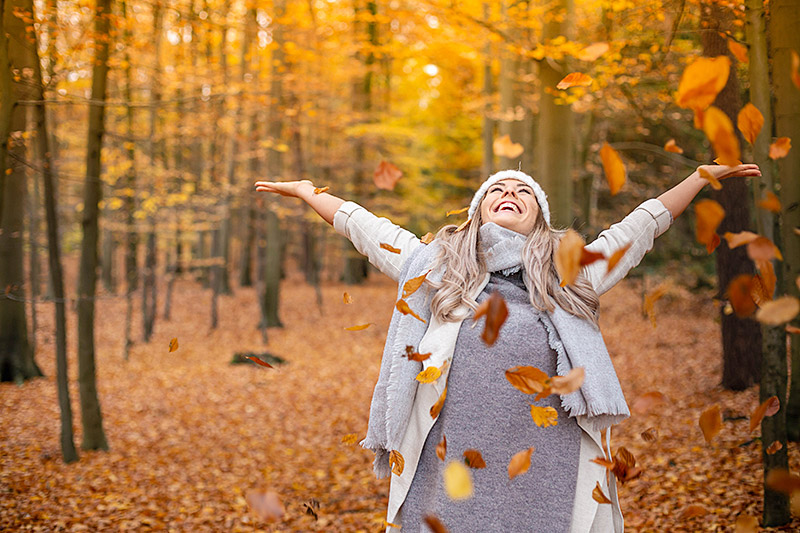 Photo of woman throwing leaves.