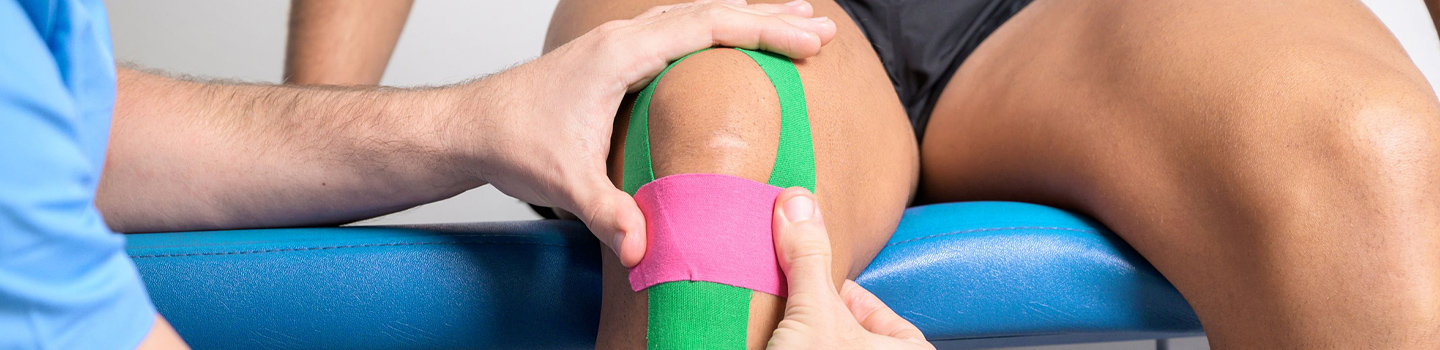 Photograph of a medical professional taping a knee