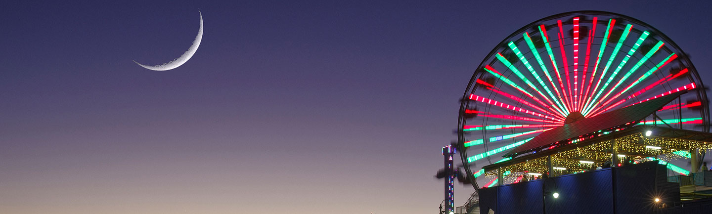 Photo of a ferris wheel and the moon
