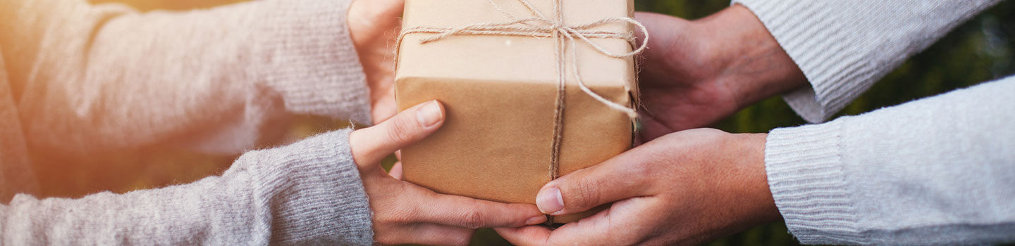 Photo of a person handing a gift to another person