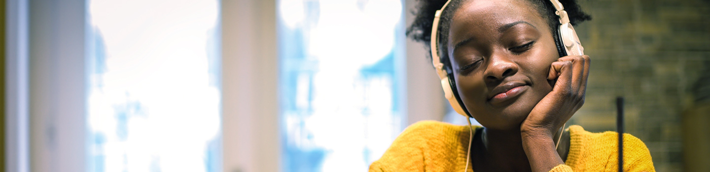 A calm young woman with headphones on