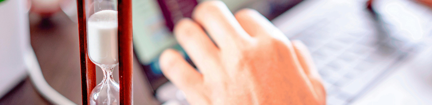 Sand timer next to a person studying
