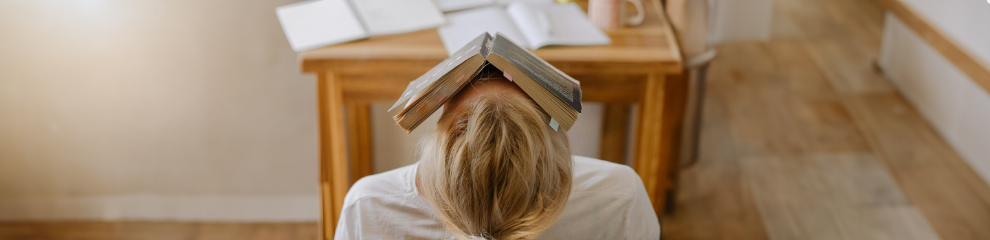 Young woman with a book resting on her face