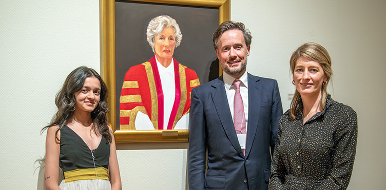 Inaugural Lady Vi Scholar, Arushi Sabnis stands with the Max Aitken, president of the Beaverbrook Canadian Foundation and Charlotte Aitken, board member, in front of a portrait of the Aitken's grandmother, Lady Violet (Vi) Aitken, at the Beaverbrook Art Gallery during a Beaverbrook Scholars celebration on Sept. 29, 2023.Inaugural Lady Vi Scholar, Arushi Sabnis stands with the Max Aitken, president of the Beaverbrook Canadian Foundation and Charlotte Aitken, board member, in front of a portrait of the Aitken's grandmother, Lady Violet (Vi) Aitken, at the Beaverbrook Art Gallery during a Beaverbrook Scholars celebration on Sept. 29, 2023.