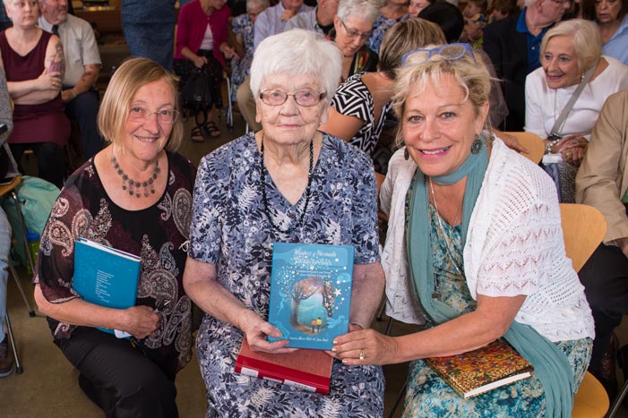 Anne Hunt, Eileen Wallace and Sheree Fitch pose with a copy of Whispers of Mermaids and Wonderful Things at UNB’s Harriet Irving Library on Sept. 21, 2017. (Cameron Fitch / Photo UNB)