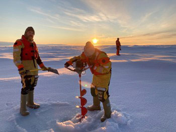 From left to right: David Barber (Researcher at the University of Manitoba and co-chief scientist of the expedition), Mathilde Guillaume (PhD student, University of Manitoba) drilling a hole through the ice, Jonathan Gagnon (Researcher at Université Laval) acting as bear guard. Photo: Audrey Limoges.