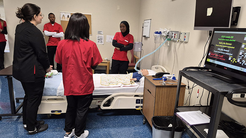Students take part in a simulation treating a “patient” who has had a tracheostomy.
