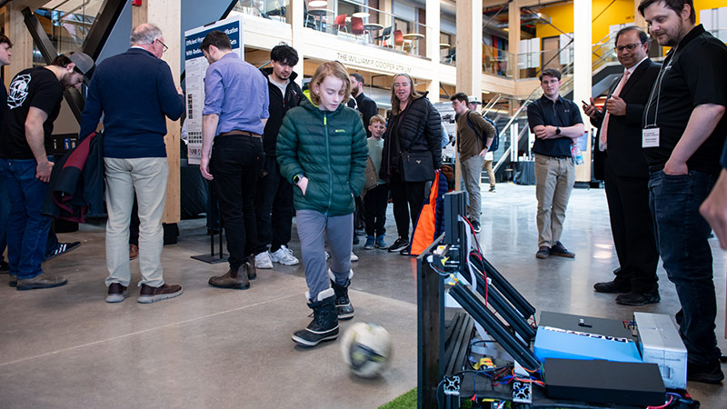 A young soccer fan tests PassTek, a smart, mobile soccer training device designed as a moving, data‑driven teammate by  Raghav Talwar, Ayush Jagtap, Anshul Rattesar and Michael Bridgland.
