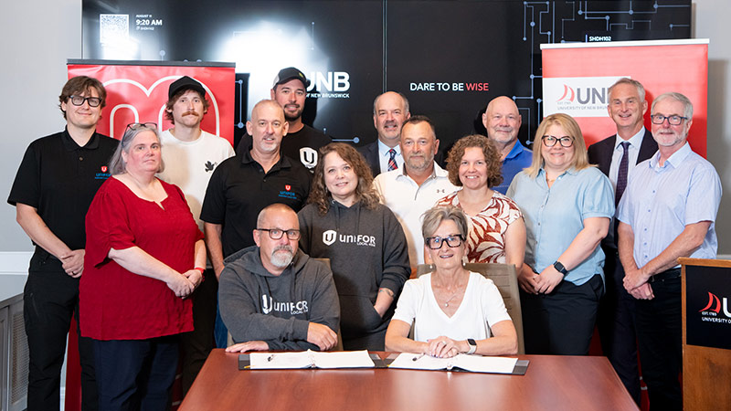 Representatives from UNB and Unifor sign collective agreement in Fredericton.