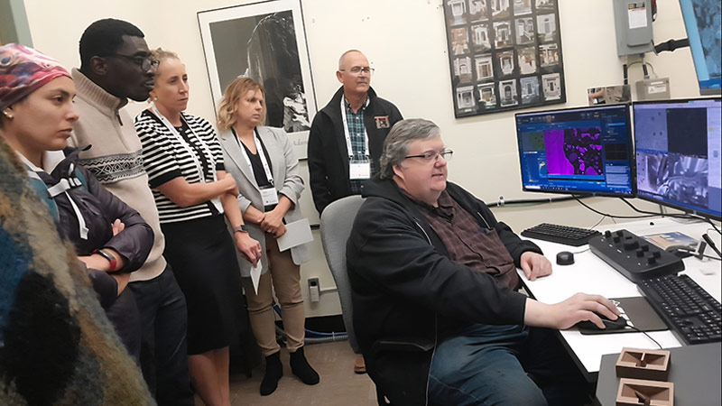 Steven Cogswell, system support engineer at the MMF, demonstrates the FIB-SEM at an Exploration, Mining, and Petroleum conference tour.
