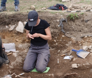 A photo of Dr. Amy Scott working in a dig site.