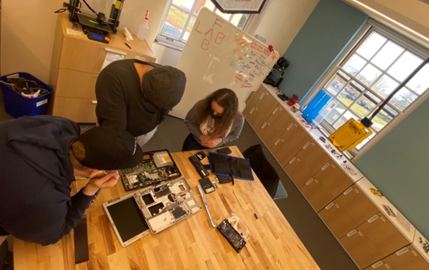 Image of people fixing a laptop at the fab lab